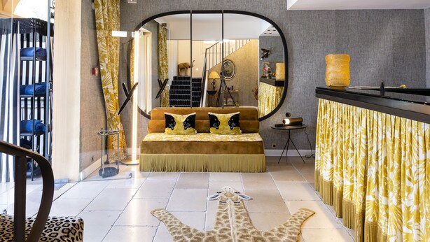 A spacious bedroom with a large bed, a giraffe rug, and a view of the staircase. - Hôtel Le Y Saint-Tropez (Saint-Tropez)