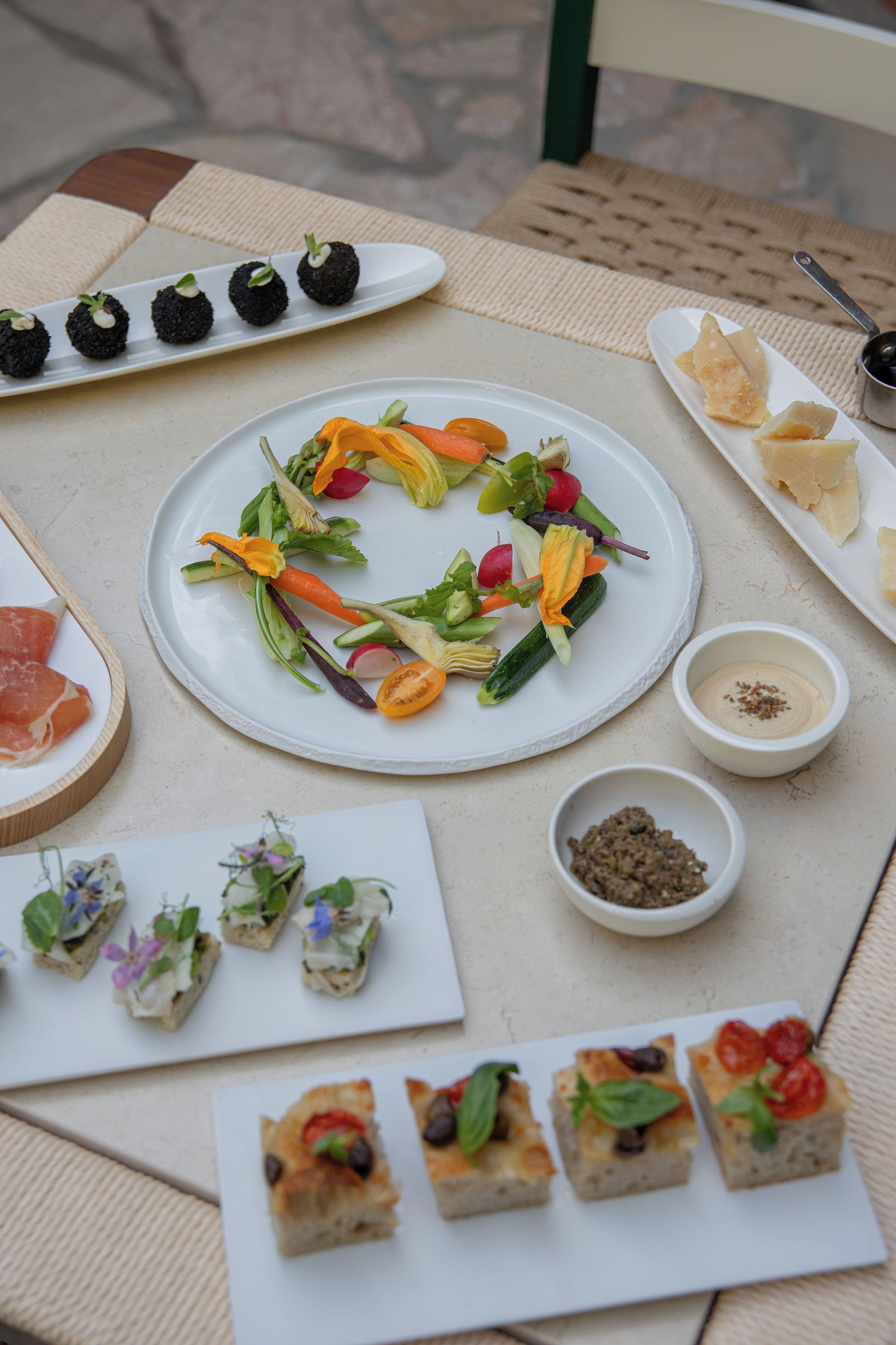 Une table où sont disposés divers aliments, notamment des amuse-gueules, des salades et une assiette de sushis.
