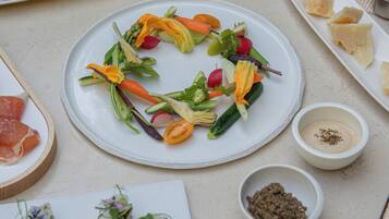 Une table où sont disposés divers aliments, notamment des amuse-gueules, des salades et une assiette de sushis.