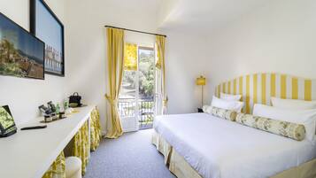 Une chambre d’hôtel avec un lit, un bureau et un balcon.