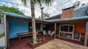 A patio area with a pool, wooden deck, and barbecue area. - Residencial Los Lapachos (Puerto Iguazú)