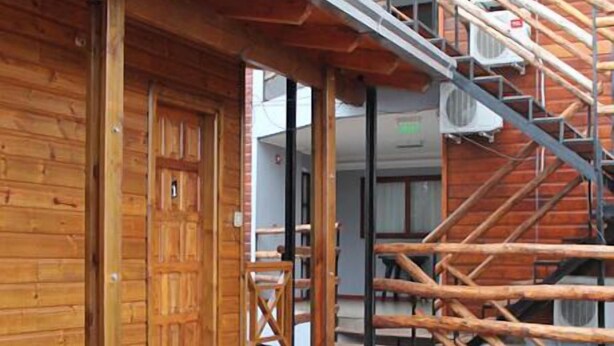 A wooden building with a staircase and a door. - Residencial Los Lapachos (Puerto Iguazú)