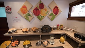 A breakfast buffet with various food items and a no-smoking sign on the wall. - Residencial Los Lapachos (Puerto Iguazú)
