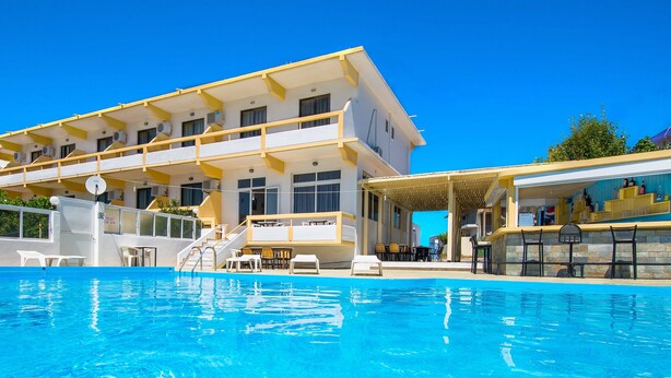 Um hotel com piscina, área de estar ao ar livre e bar.