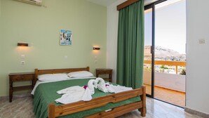 Quarto de hotel com uma cama, mesa de cabeceira, ar condicionado, quadro, cortina e varanda com vista.