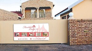 Een bakstenen muur met een bord voor Furnace Lodge, inclusief een telefoonnummer en e-mailadres.