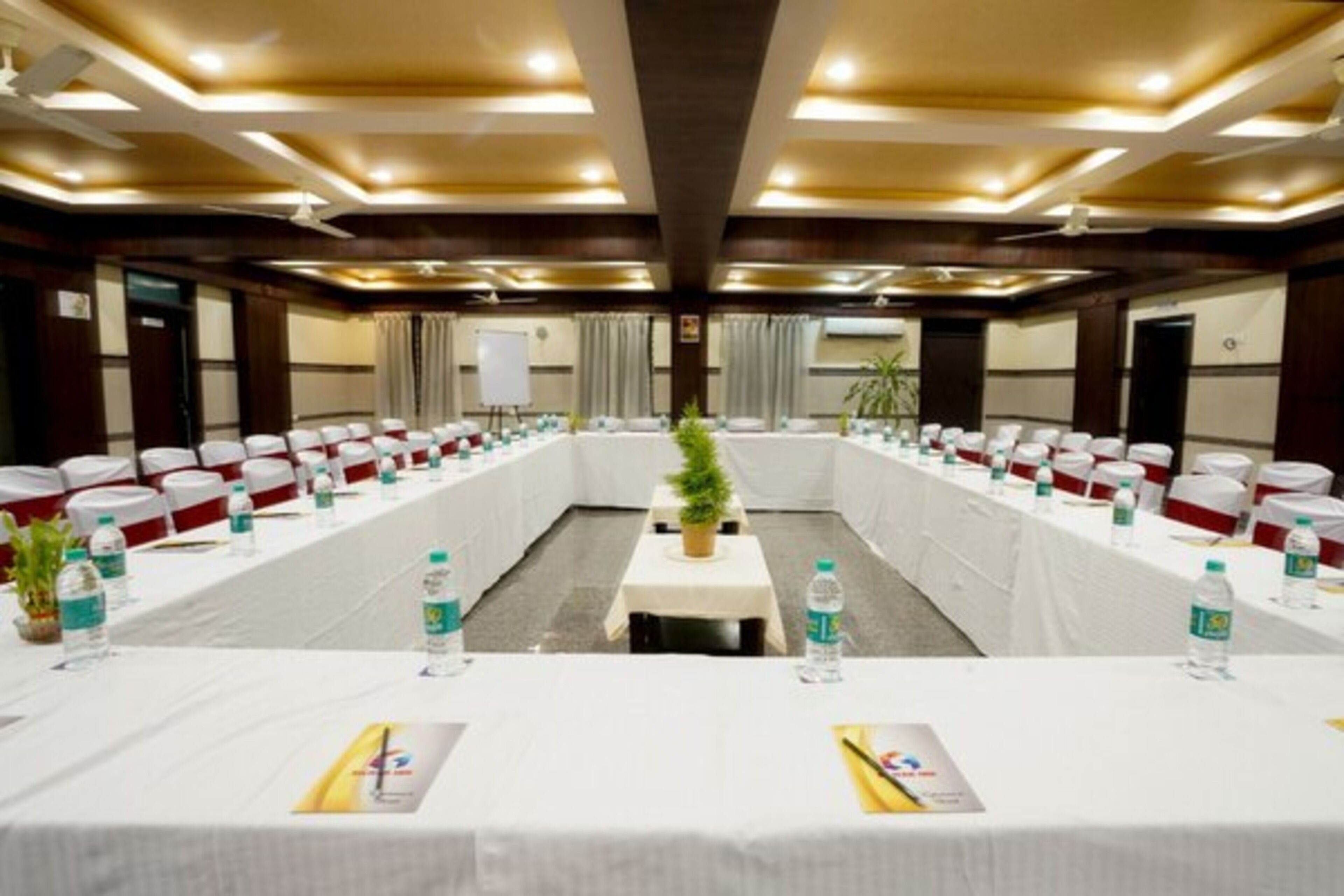 A conference room with a long table, chairs, water bottles, and a whiteboard.