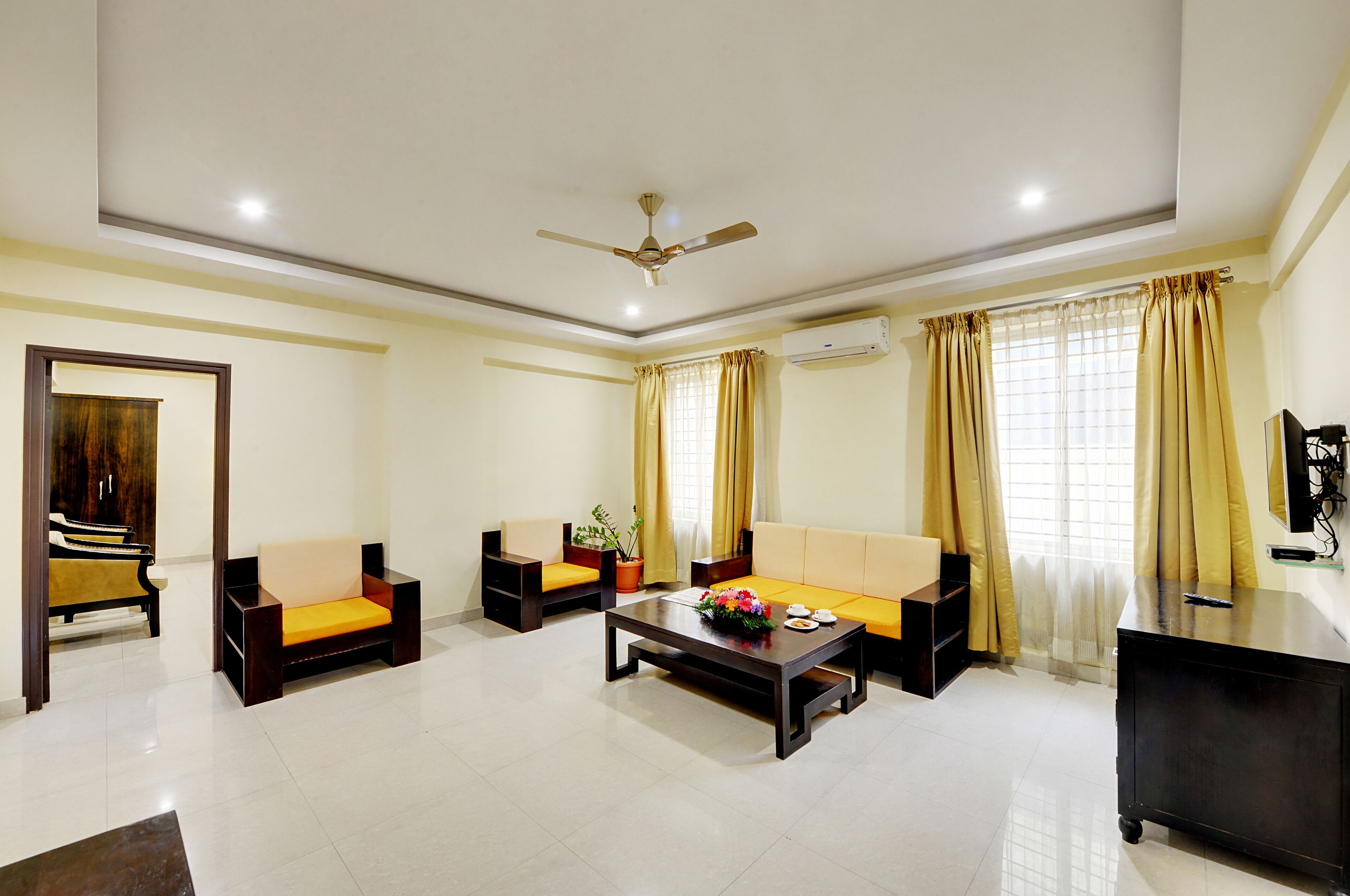 A modern living room with a sofa, armchairs, a coffee table, and a TV.