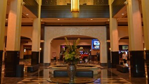 A spacious lobby with a high ceiling, a central seating area, and a large vase of flowers. - Mountaineer Casino Resort (New Cumberland)