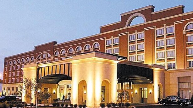 A multi-story hotel with a prominent entrance featuring a covered walkway and arched windows. - Mountaineer Casino Resort (New Cumberland)