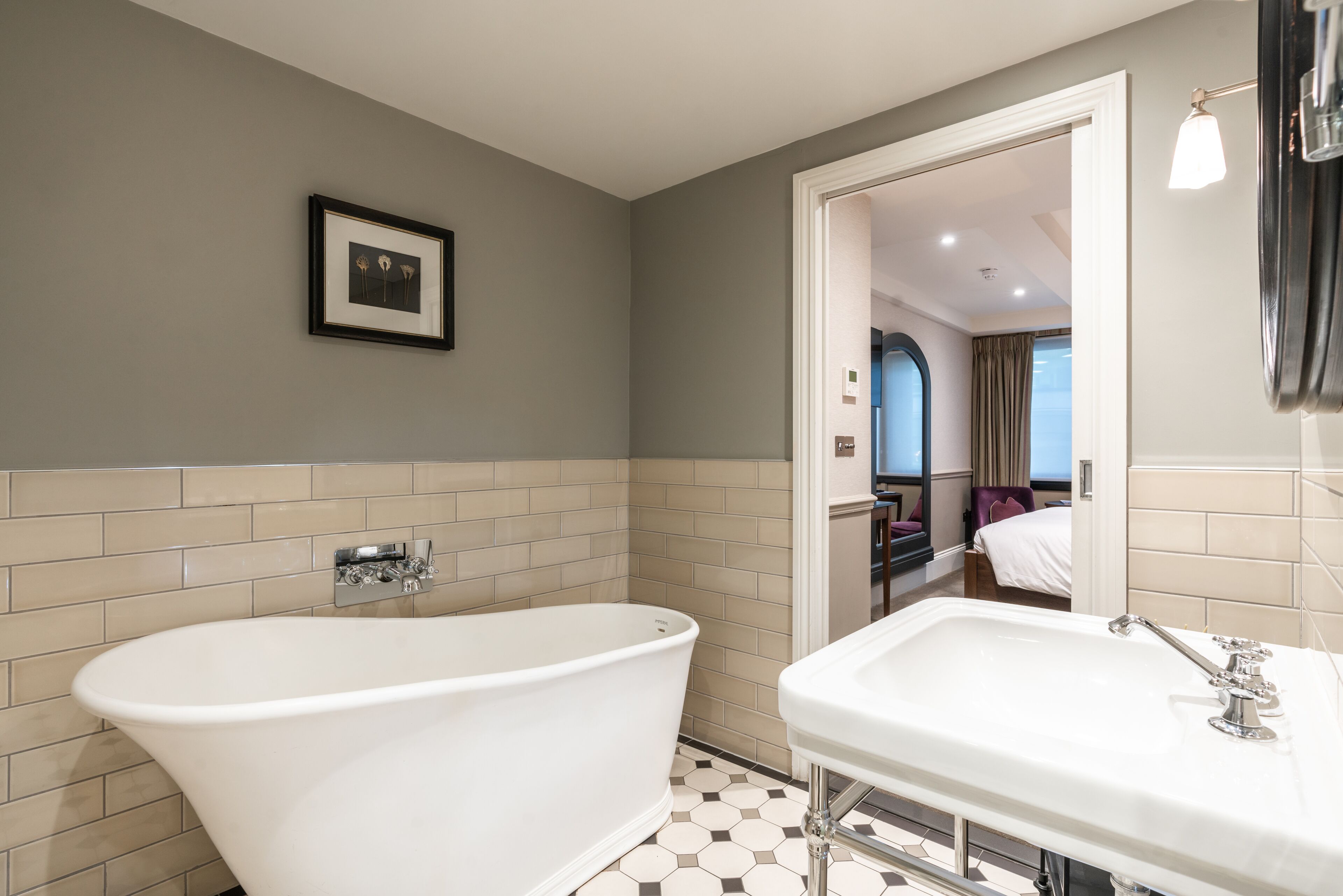 A modern bathroom with a freestanding bathtub, a sink, and a mirror.