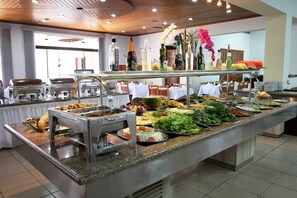 Una mesa de buffet con diversos alimentos y salsas.