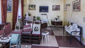 Una sala de estar con piso a cuadros, un sofá, una mesa de centro, un televisor y un mural en el techo.