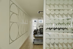 Work out in style with a modern gym featuring treadmills, a partition, and access to additional space.