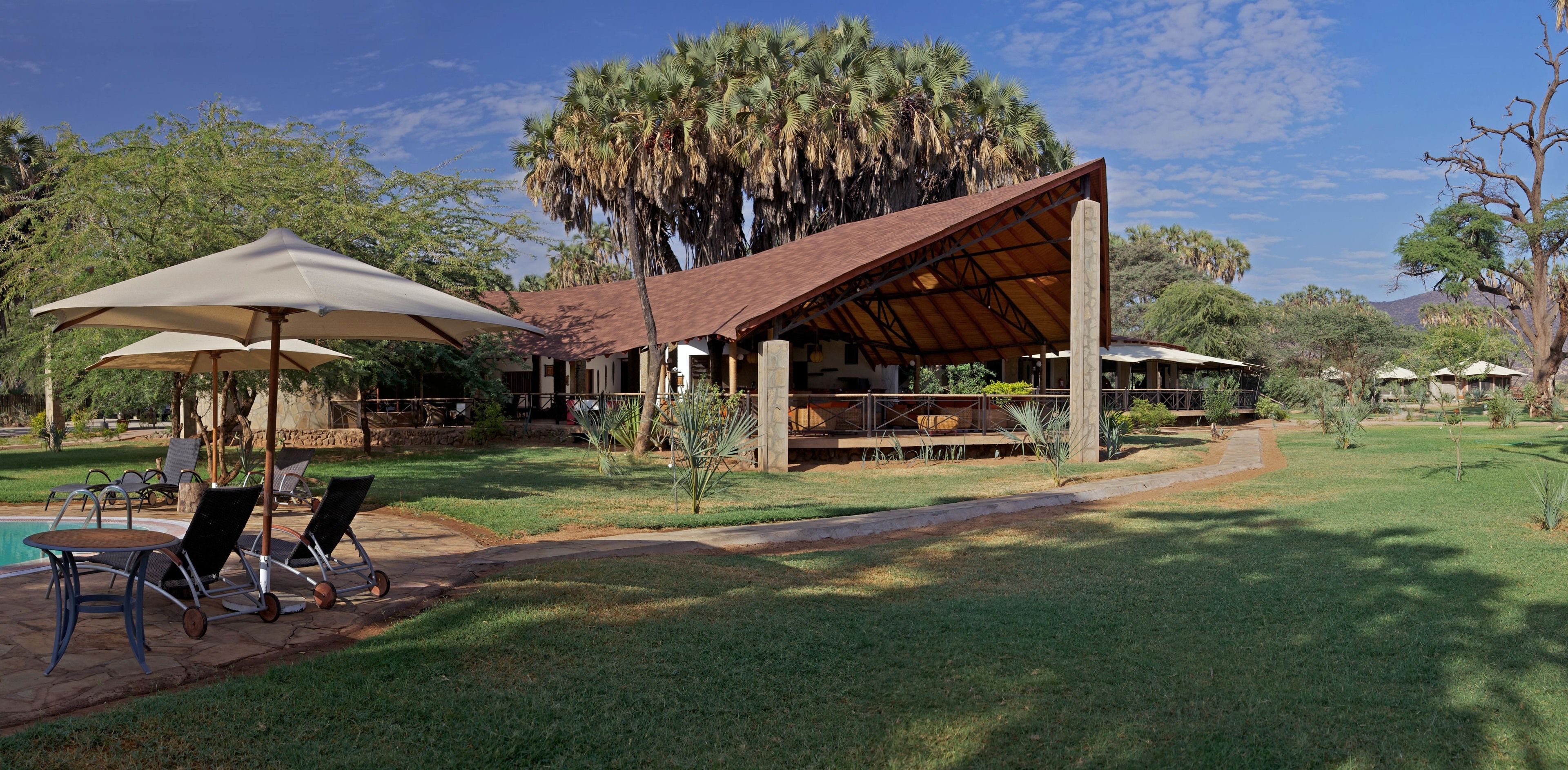 A resort with outdoor seating, a pool, and a covered patio area.