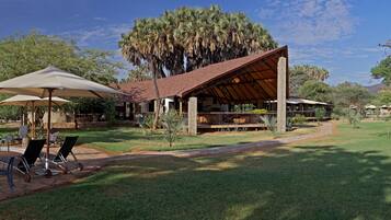 A resort with outdoor seating, a pool, and a covered patio area.