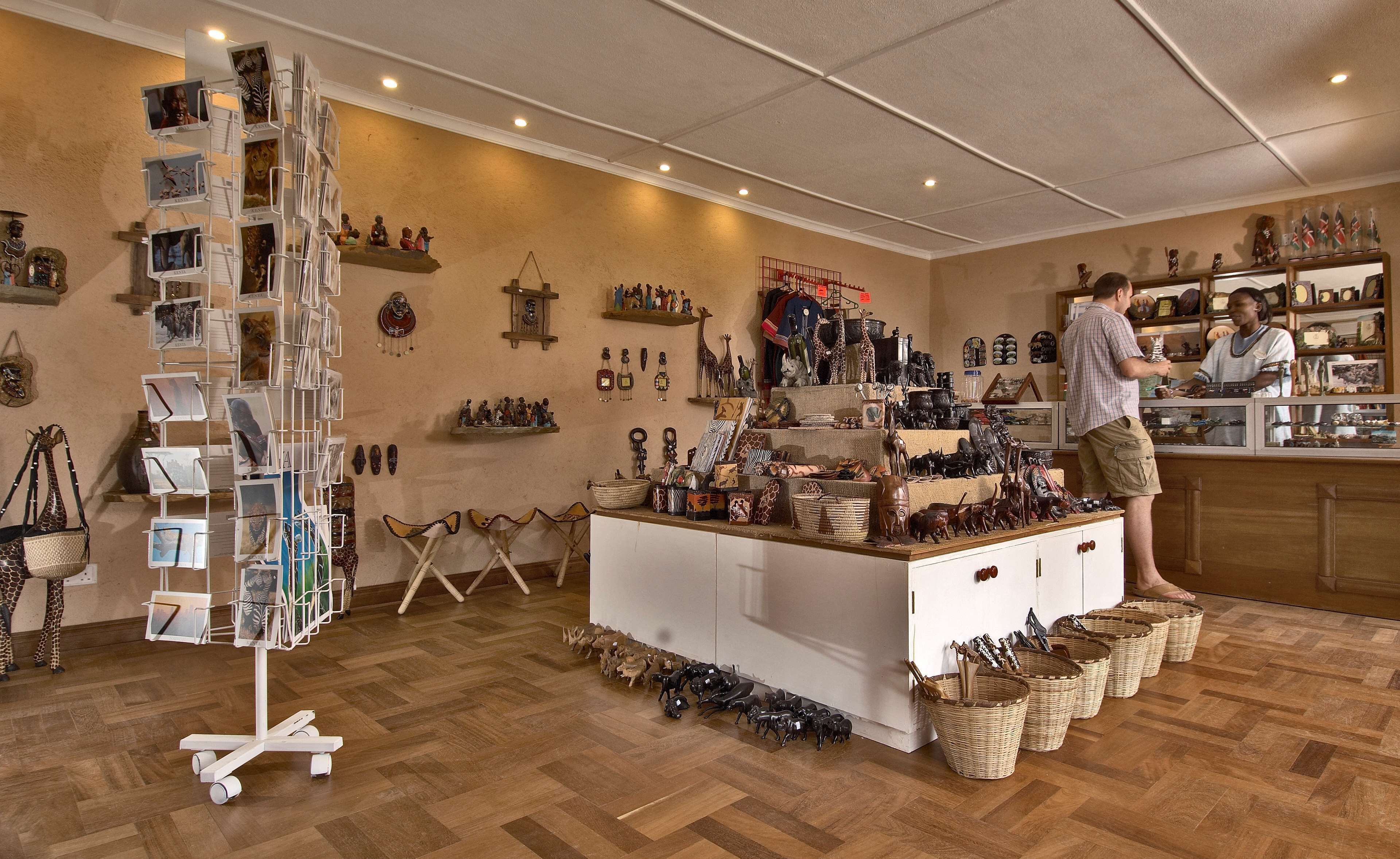 A boutique with wooden flooring, a central display table, and various items on shelves and walls.