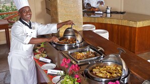 A buffet setup with labeled dishes like 'Fish Coulombs', 'Braised Beef', and 'Lyonnaise Potatoes'. - Ashnil Aruba Lodge (Voi)