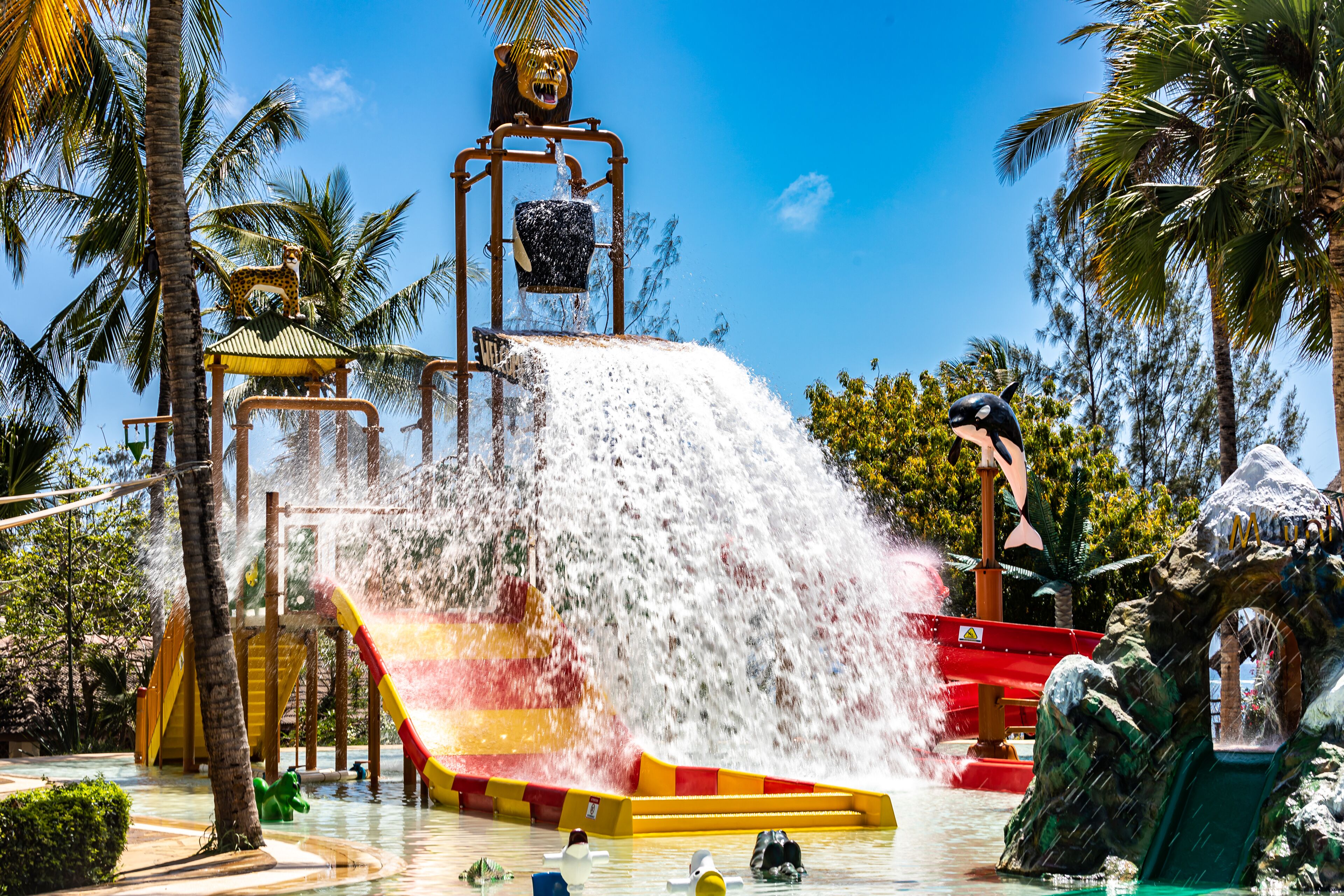 A water park with a large waterfall, slides, and various water features.