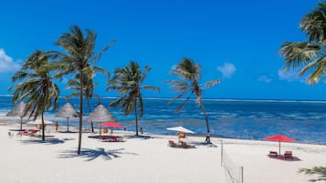 Een privéstrand, ligstoelen aan het strand, parasols, strandlakens