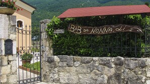 Un muro de piedra con una reja de metal y un cartel que dice "B&B da Noia".