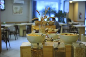 A dining area with tables, chairs, and a buffet setup with bowls and containers.