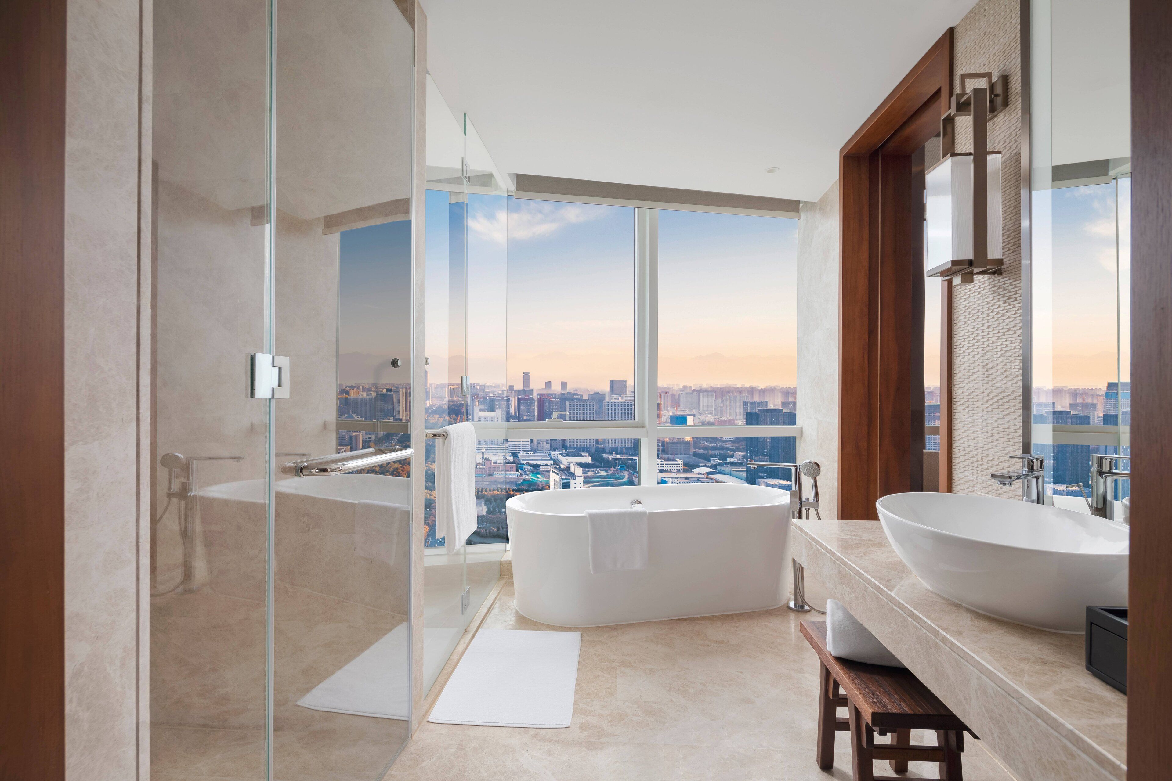A modern bathroom with a large bathtub, a separate shower area, and a vanity with a large sink.