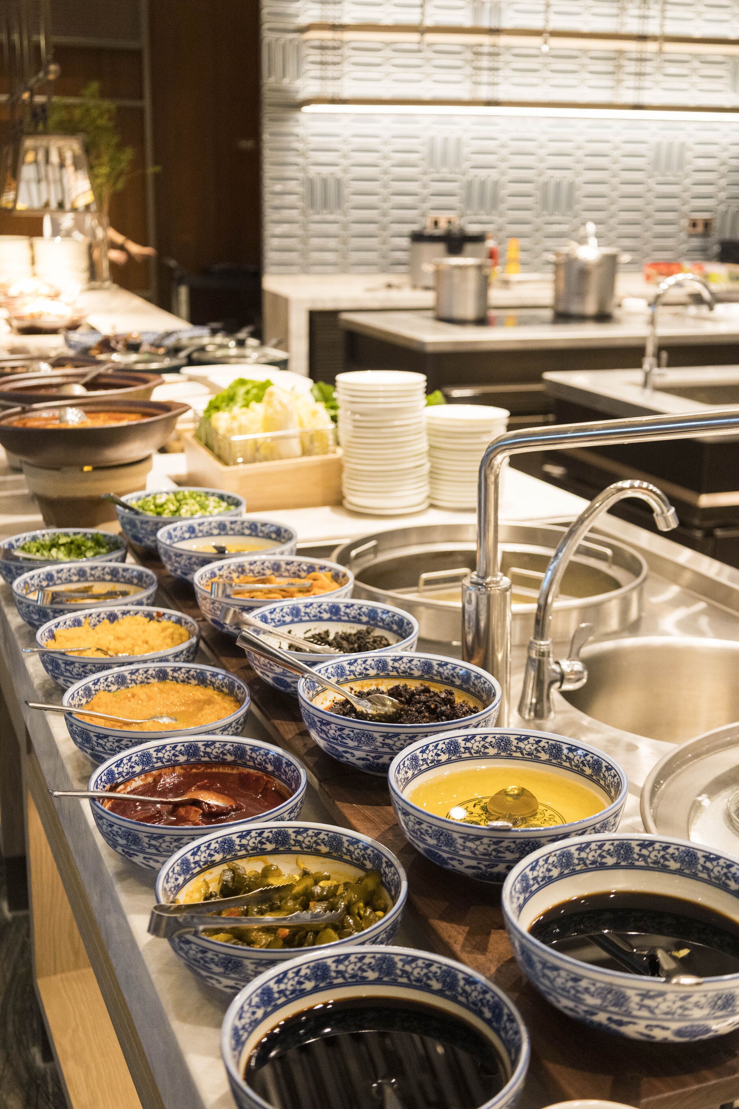 Un buffet proposant divers plats présentés dans des bols aux motifs bleus et blancs.