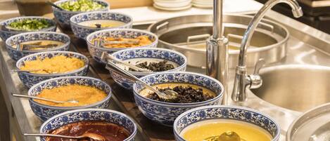 Un buffet proposant divers plats présentés dans des bols aux motifs bleus et blancs.