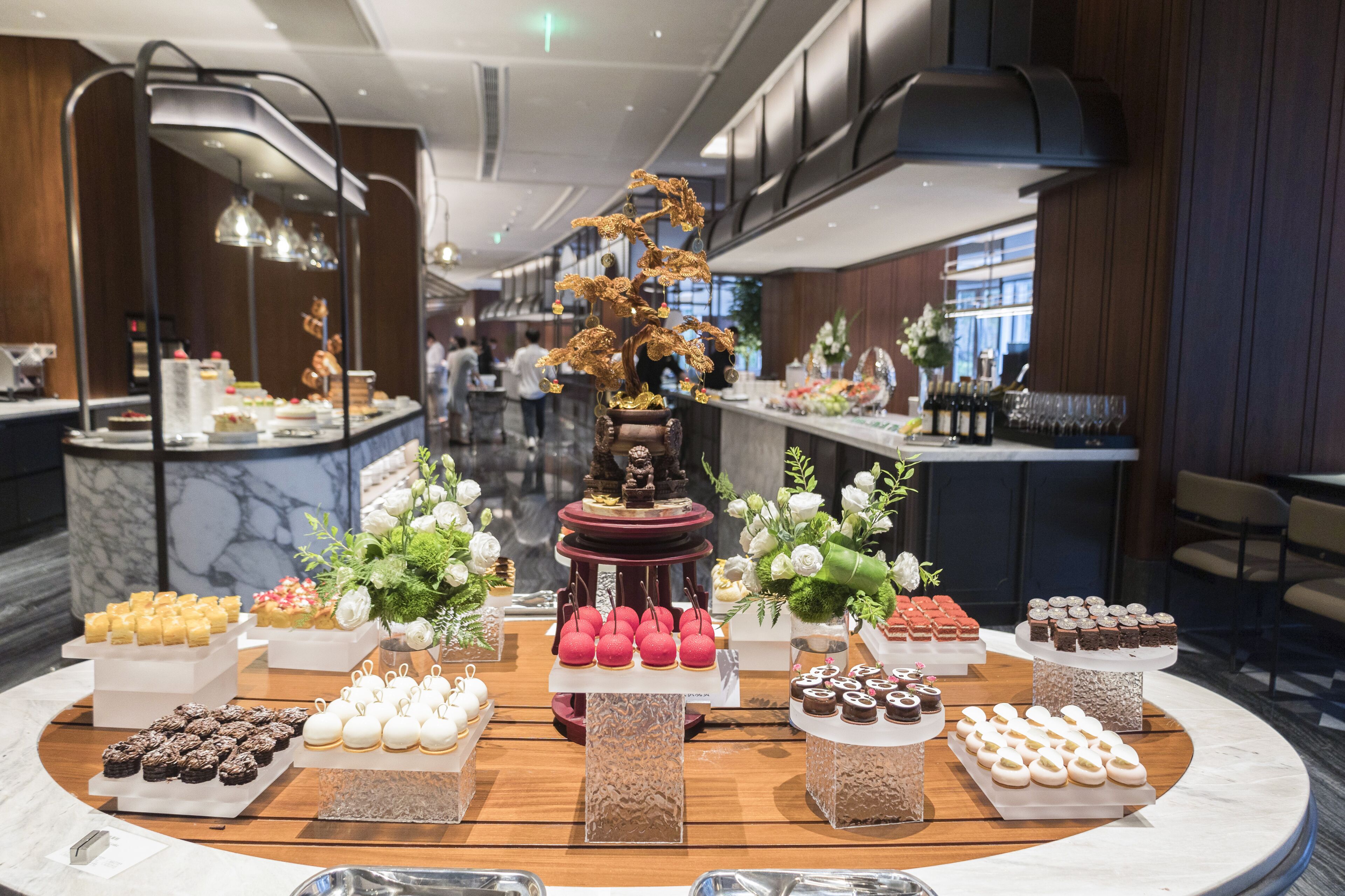 A buffet with various desserts and a decorative centerpiece.