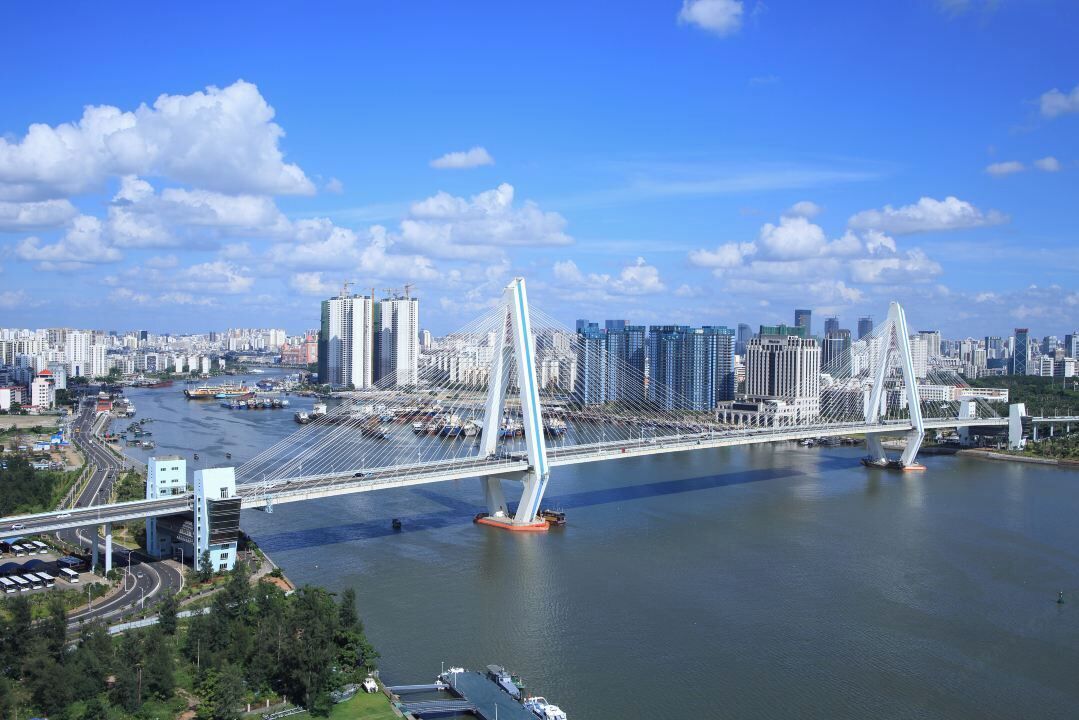 A cityscape with a prominent bridge spanning a river, surrounded by high-rise buildings.