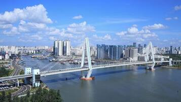 Un paisaje urbano con un puente destacado que cruza un río, rodeado de rascacielos.