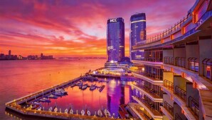 A waterfront hotel with a marina, modern architecture, and a city skyline in the background. - InterContinental Haikou Seaview by IHG (Haikou)
