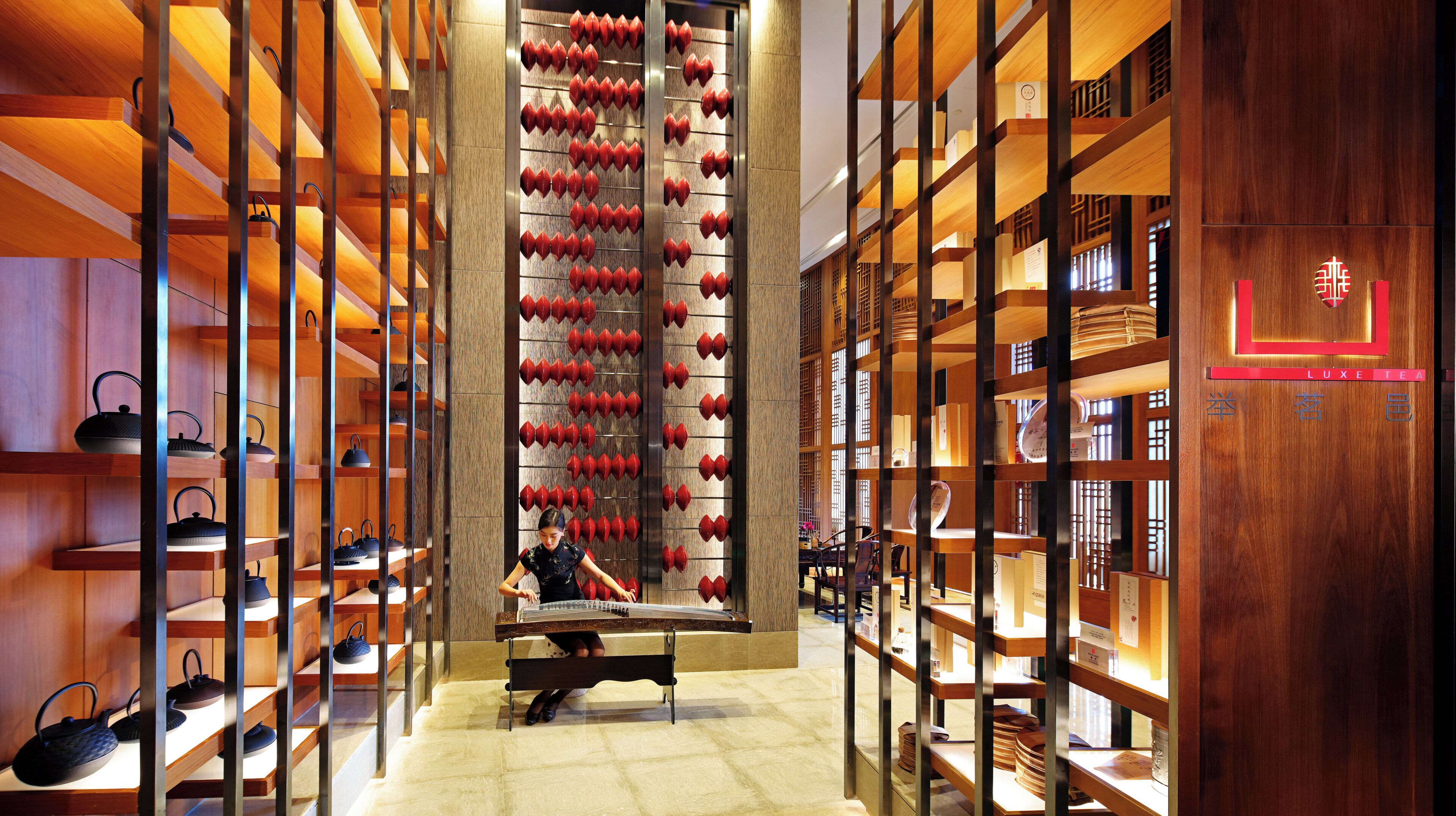 A luxury tea shop with wooden shelves and a central display of teapots.