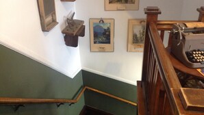 A staircase with wooden handrails, a vintage typewriter, and framed pictures on the wall.