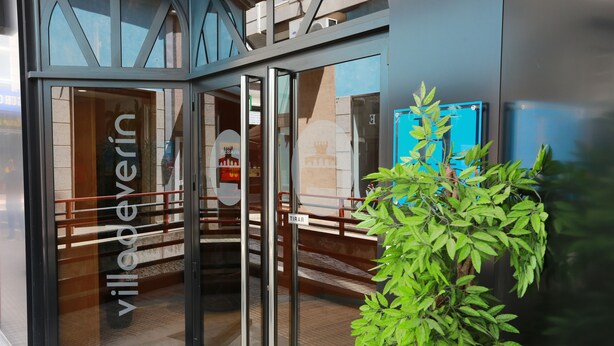 A modern building entrance with glass doors and a sign reading "villagein".