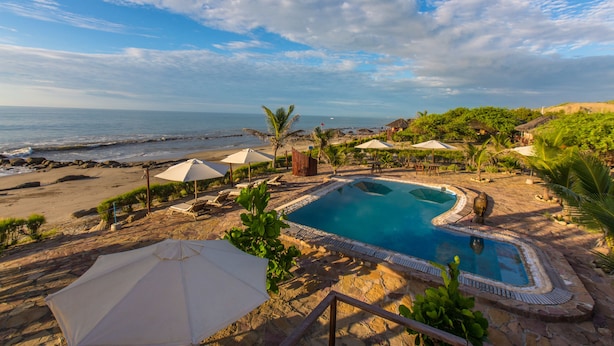 Zona de piscina con vista a la playa y al océano.