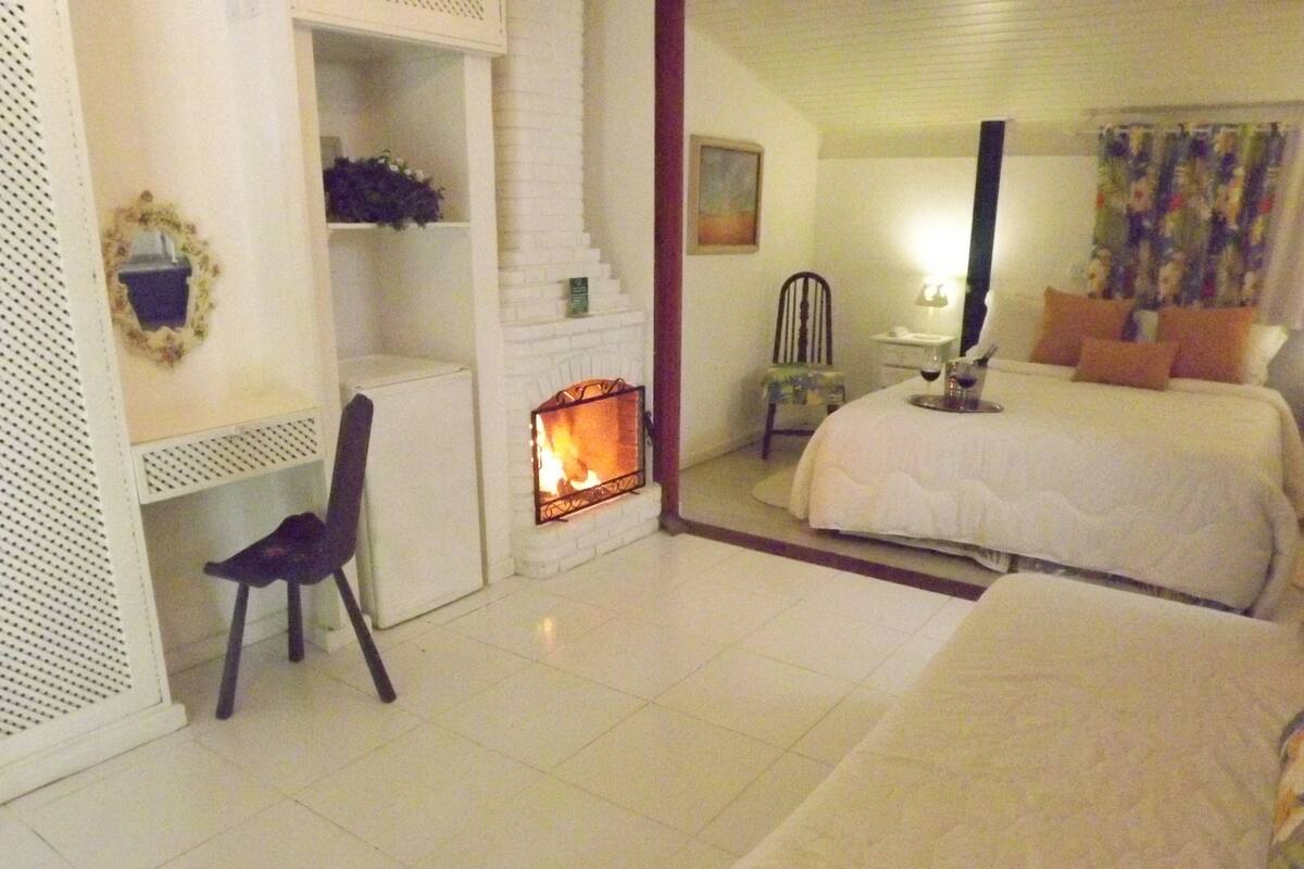 Ein Hotelzimmer mit Kamin, Bett, Sessel und Nachttisch.
