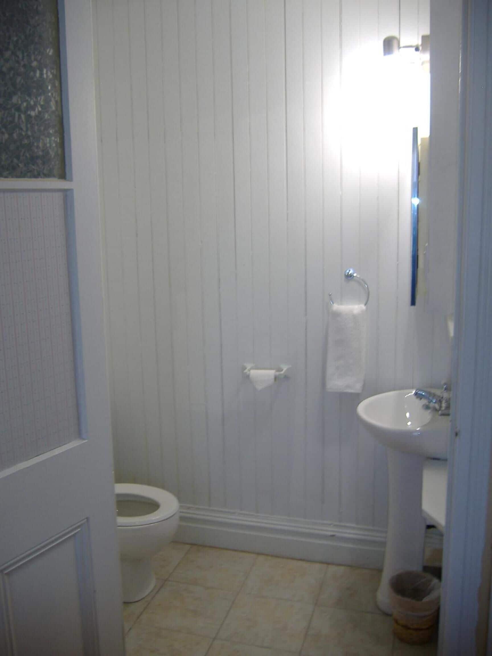 Ein Badezimmer mit Toilette, Waschbecken und Spiegel.