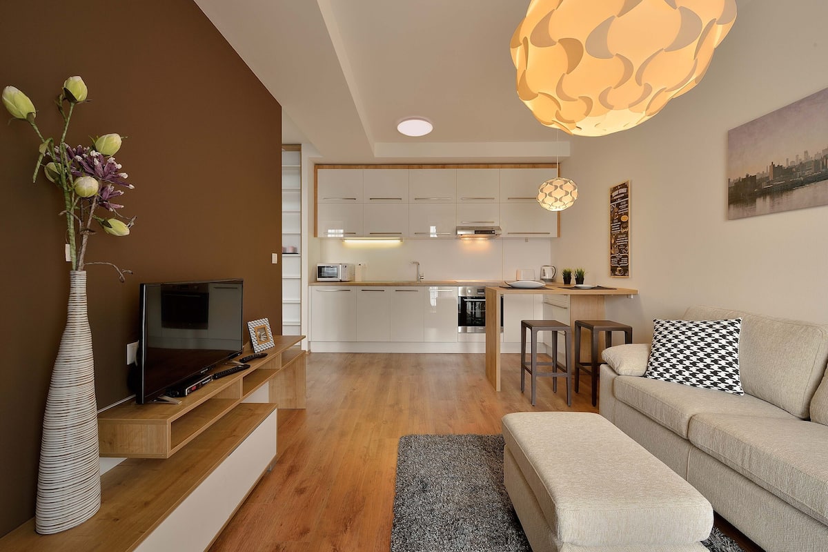 A modern living room with a TV, sofa, and a decorative vase.