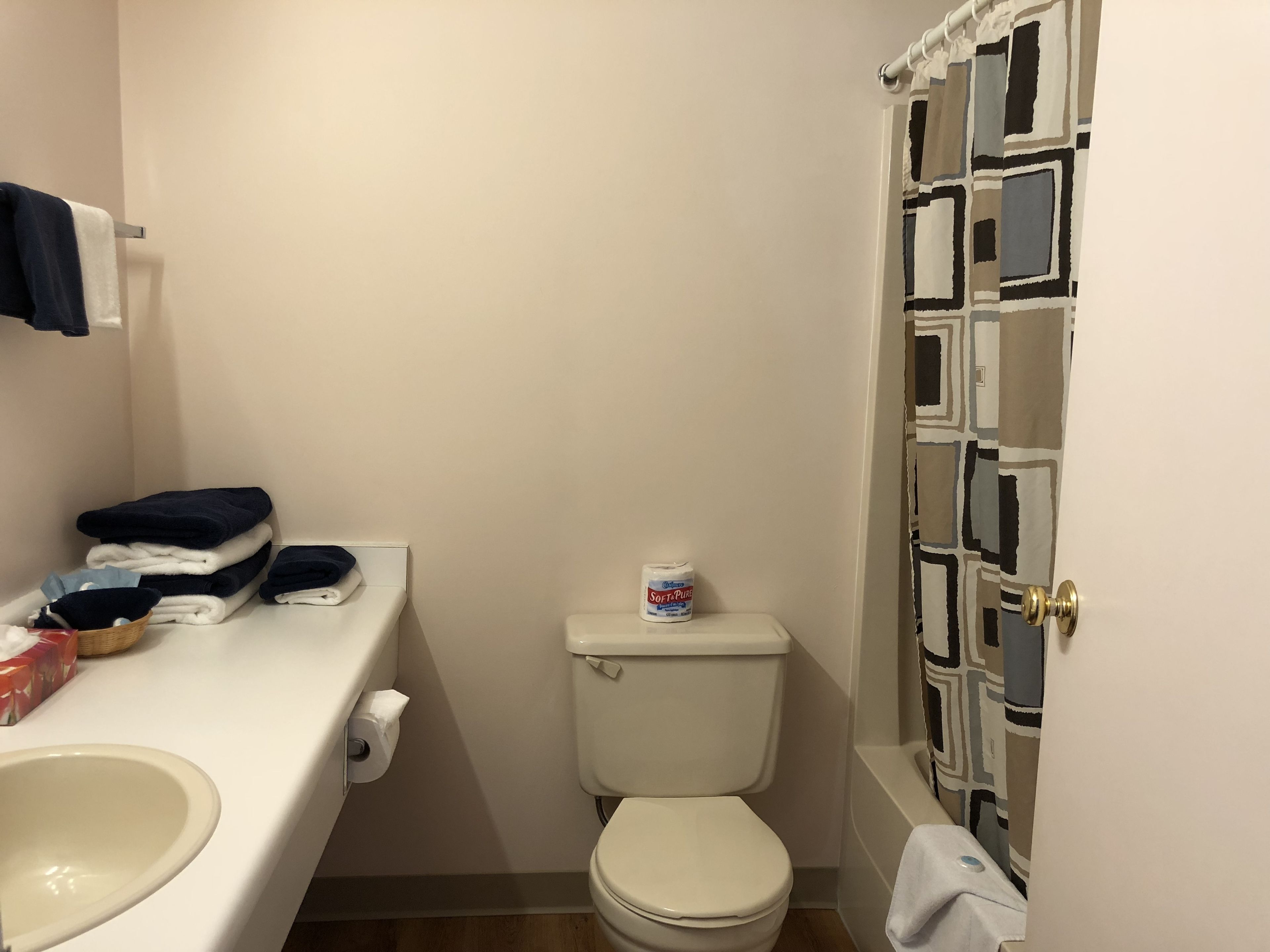 A small, clean bathroom with a toilet, sink, and a towel rack.
