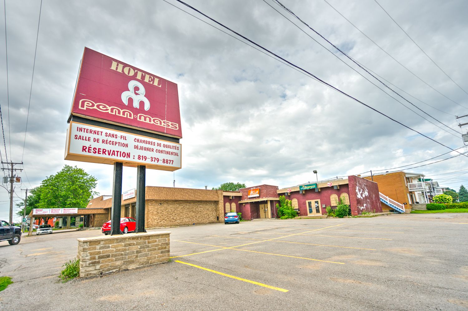 A hotel with a sign indicating internet service, a reception area, and a parking lot.