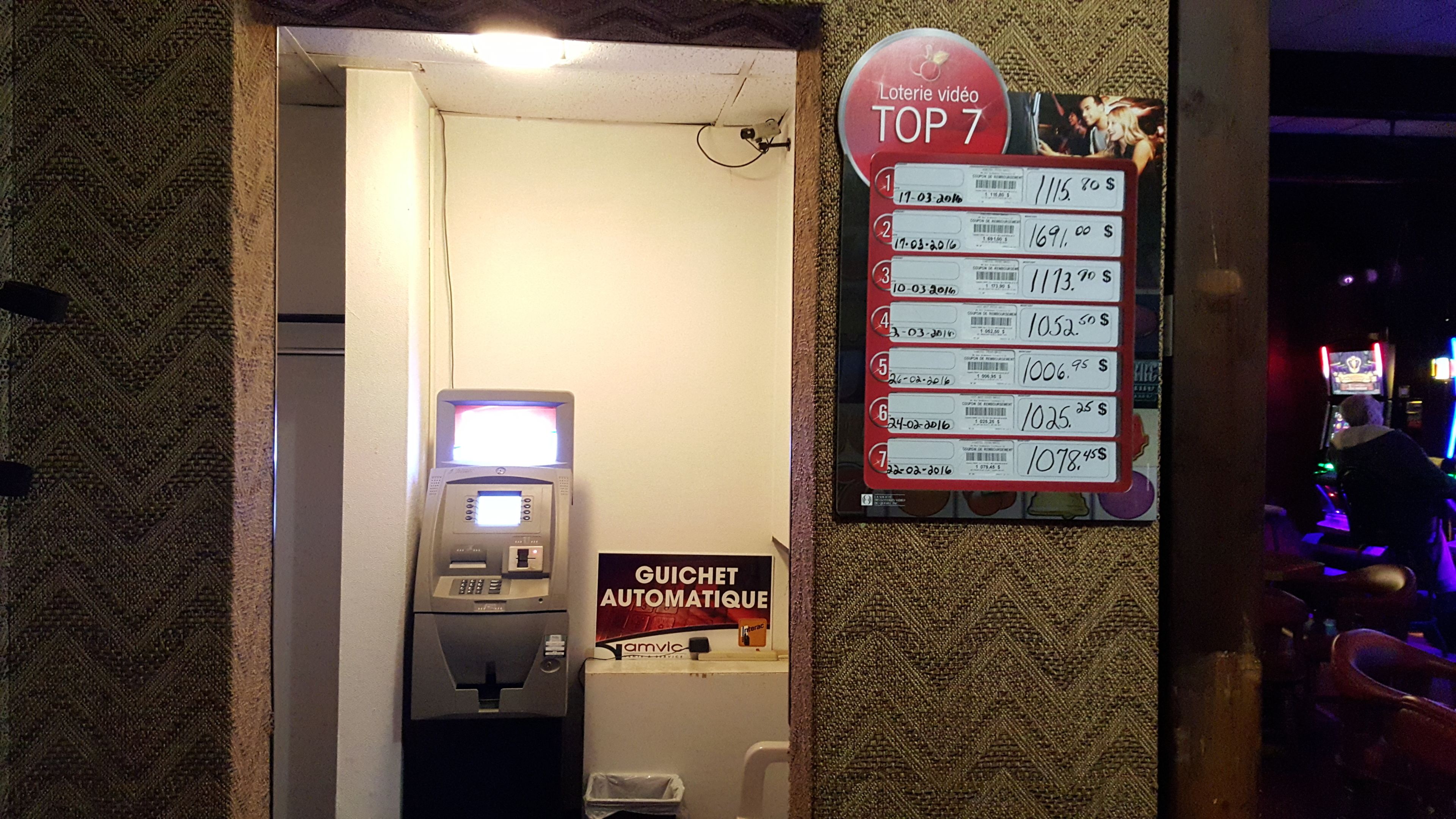 A slot machine area with a sign listing the top 7 jackpots.
