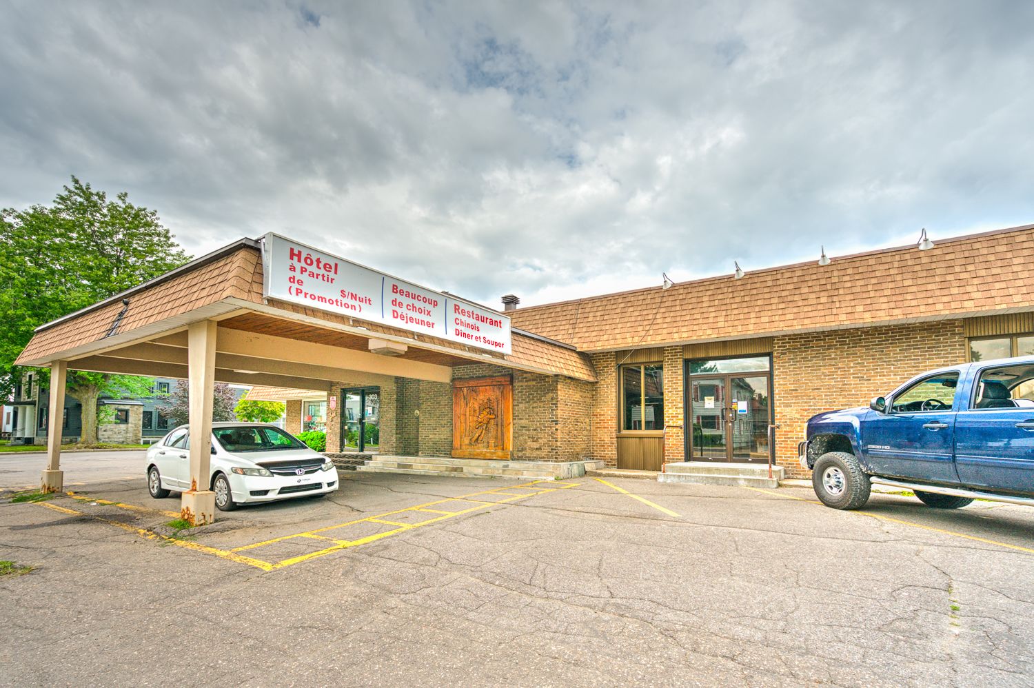Een hotel met een overdekte parkeerplaats, een restaurant en een Chinees restaurant.