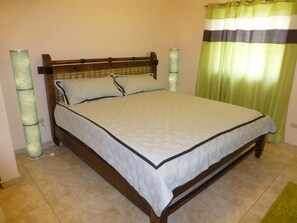 A single bed with a wooden frame and white bedding in a room with tiled flooring. - Studio Ocean Dream (Cabarete)