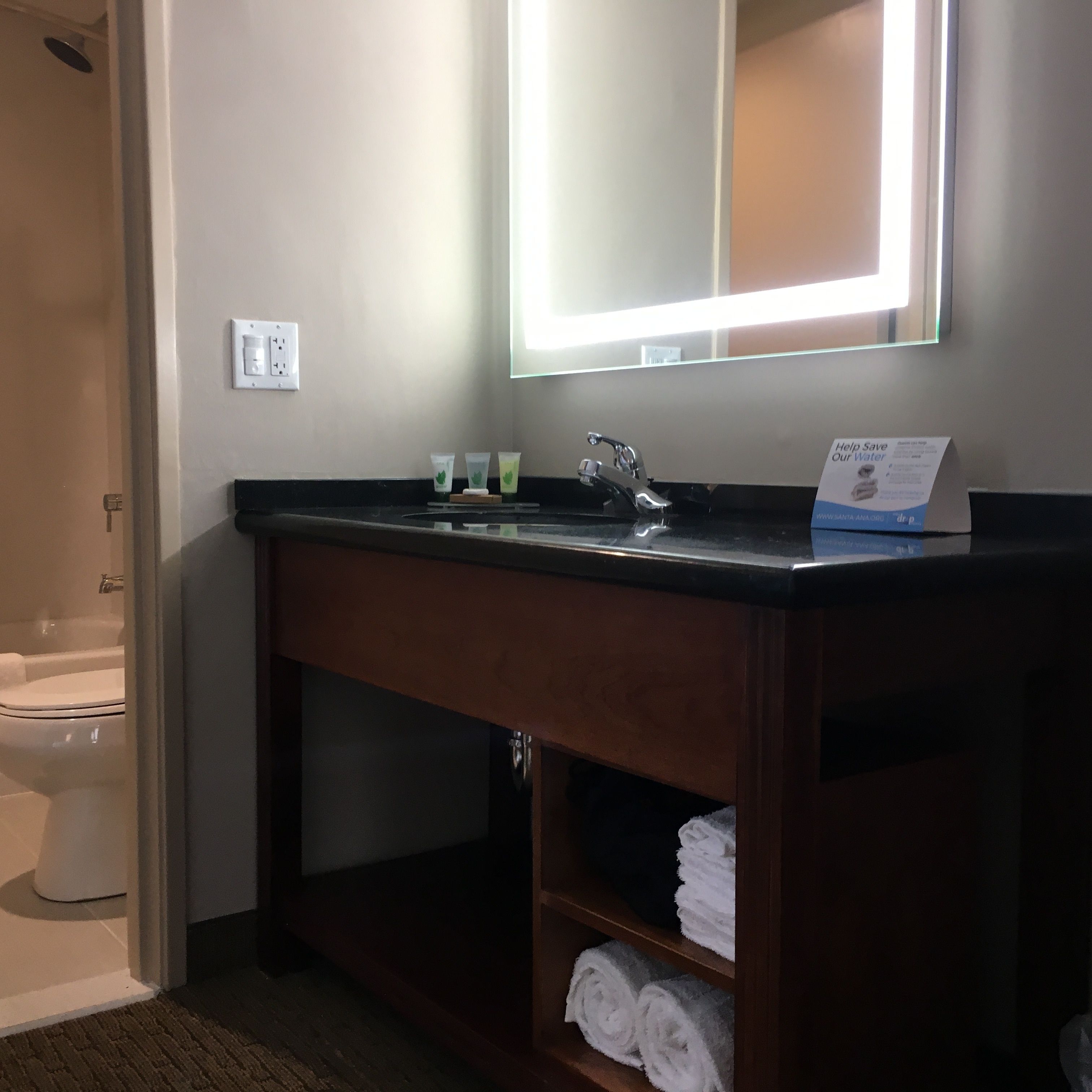 A bathroom with a sink, mirror, and towel rack.