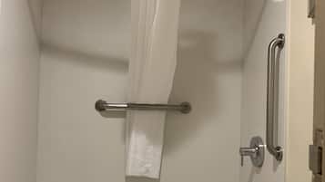 Un baño moderno con bañera, ducha y barra de apoyo.