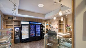 A gift shop with a Pepsi refrigerator, shelves with various items, and a glass display case with knick-knacks.