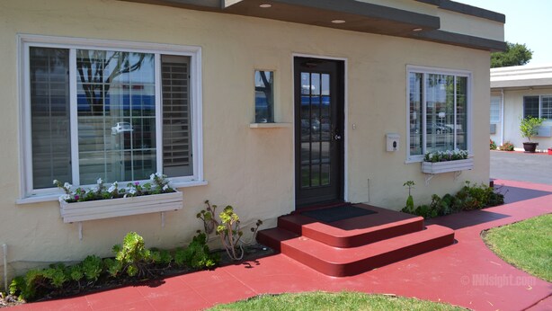 A modern two-story house with a black front door, white-framed windows, and a red front porch. - Wittle Inn (Sunnyvale)