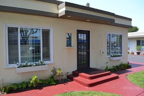 A modern two-story house with a black front door, white-framed windows, and a red front porch. - Wittle Inn (Sunnyvale)
